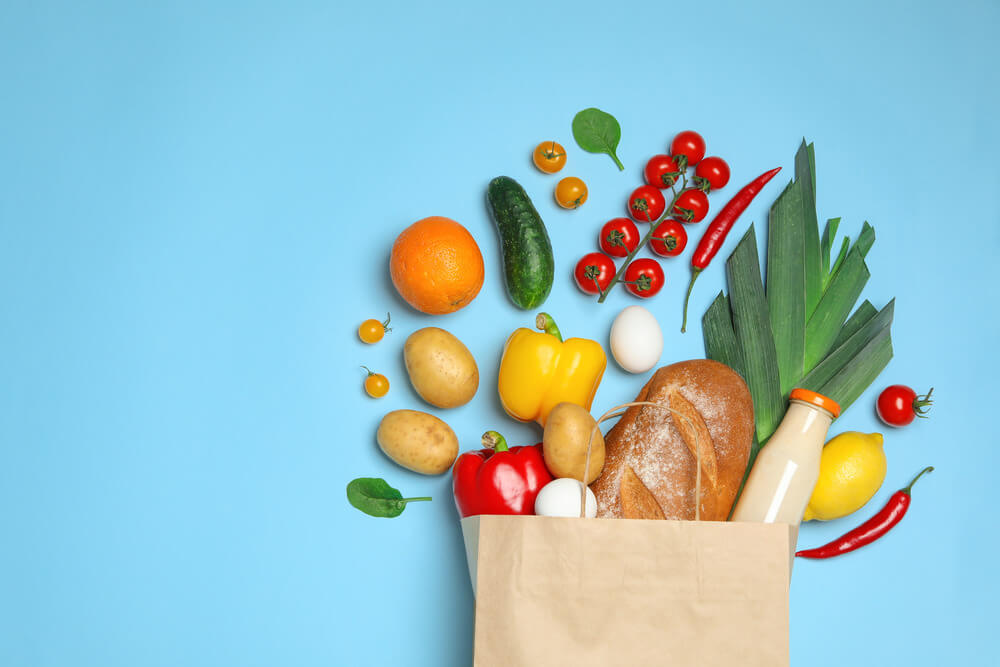 Full grocery bag on light blue background